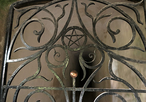Those Who Enter The Crypt Must Go Through A Gate Adorned With A Pentagram, Hinting At The Magical Dimension Of The Place.